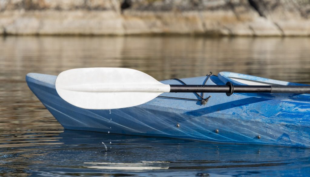 Kayak Paddle With Water Drops Hitting The Lake